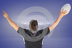 Composite image of back turned rugby player gesturing victory