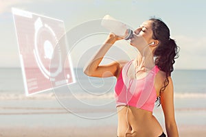 Composite image of beautiful healthy woman drinking water on beach