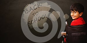 Composite image of boy sitting in wheelchair in school