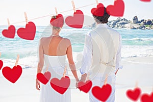 Composite image of bride and groom holding hands looking out to sea