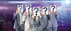 Composite image of business colleagues hiding their face with question mark sign