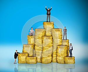 Composite image of business people on pile of coins