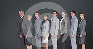 Composite image of business team standing in row and smiling at camera