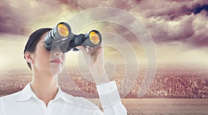 Composite image of business woman looking through binoculars