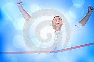 Composite image of businessman crossing the finish line