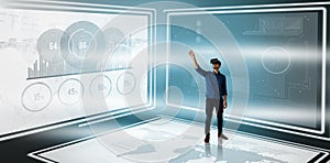 Composite image of businessman gesturing while looking though virtual reality simulator