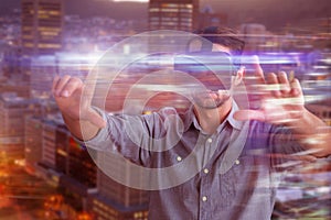 Composite image of businessman gesturing while using virtual reality simulator