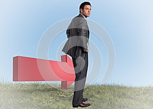 Composite image of businessman with hands on hips