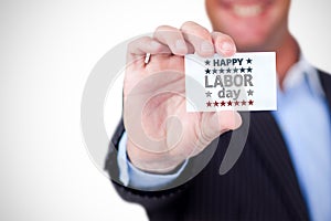 Composite image of businessman holding blank card against white background