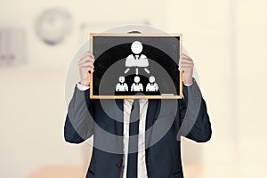 Composite image of businessman holding board