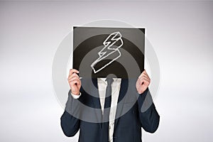 Composite image of businessman holding board