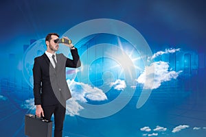 Composite image of businessman holding a briefcase while using binoculars