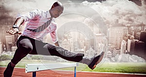 Composite image of businessman jumping a hurdle photo