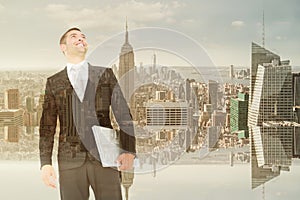 Composite image of businessman looking up holding laptop