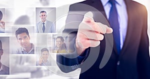 Composite image of businessman pointing his finger at camera