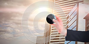 Composite image of businessman in suit holding little earth