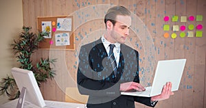 Composite image of businessman in suit typing on laptop