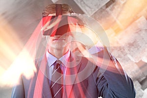 Composite image of businessman in suit using virtual reality headset