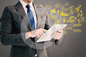 Composite image of businessman using his tablet pc