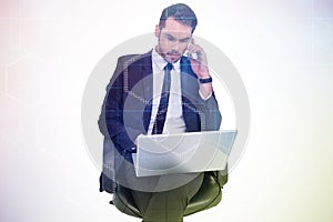 Composite image of businessman using laptop while phoning