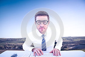 Composite image of businessman working at his desk