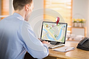 Composite image of businessman working on his laptop