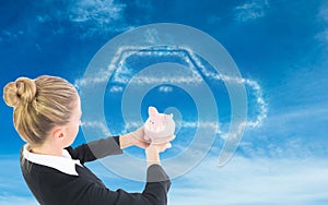 Composite image of businesswoman holding piggy bank