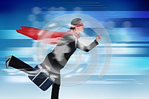 Composite image of businesswoman running while pretending to be super hero