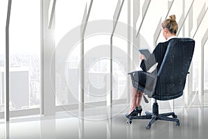 Composite image of businesswoman sitting on swivel chair with tablet photo