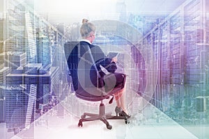 Composite image of businesswoman sitting on swivel chair with tablet photo