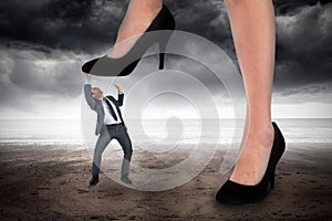 Composite image of businesswoman stepping on tiny businessman