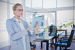 Composite image of businesswoman using digital tablet