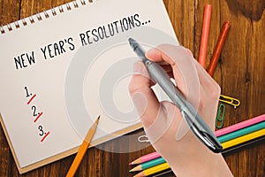 Composite image of businesswomans hand writing with pen