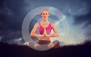 Composite image of calm blonde sitting in lotus pose with hands together