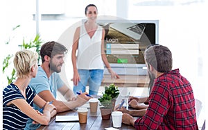 Composite image of casual businesswoman giving presentation to her colleagues