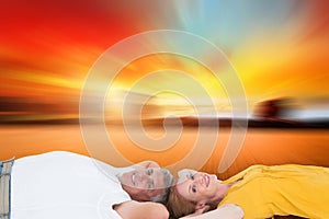 Composite image of casual couple lying on floor