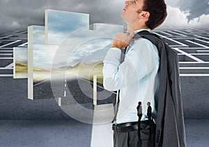 Composite image of caucasian businessman looking up against road and maze in background