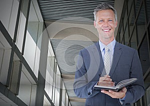 Composite image of caucasian senior businessman taking notes against office interior in background