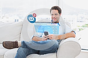 Composite image of cheerful man sitting on the couch using his smartphone