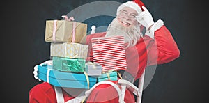 Composite image of cheerful santa claus holding chritmas presents while sitting on chair