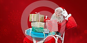 Composite image of cheerful santa claus holding chritmas presents while sitting on chair