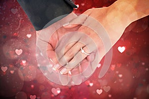 Composite image of close-up of bride and groom with hands together