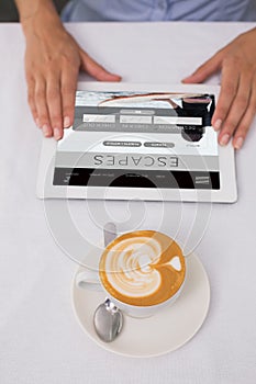 Composite image of close-up of digital tablet and coffee on table