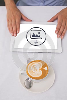 Composite image of close-up of digital tablet and coffee on table