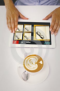 Composite image of close-up of digital tablet and coffee on table