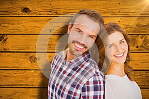 Composite image of close up of happy young couple standing back to back