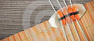 Composite image of close up of salmon sushi with chopsticks in plate