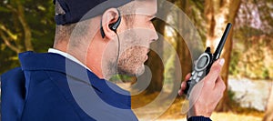 Composite image of close up of security officer talking on walkie talkie