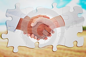 Composite image of close-up shot of a handshake in office