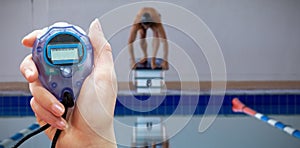 Composite image of close up of woman is holding a stopwatch on a white background